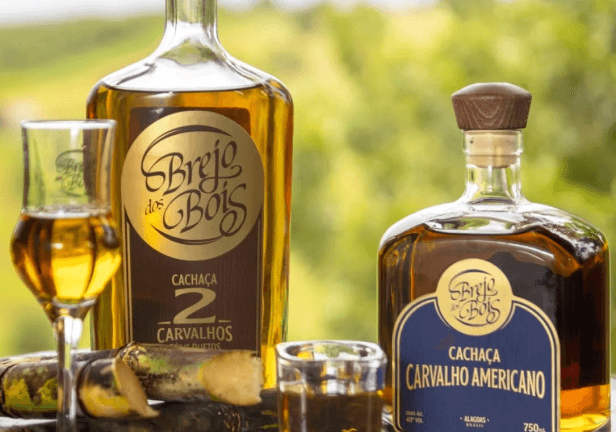 Foto de duas cachaças acompanhadas de um copo